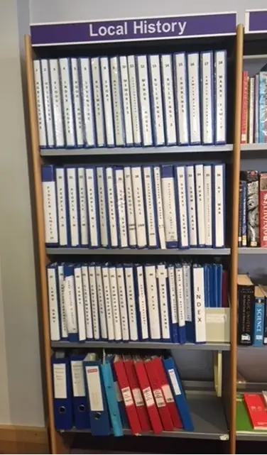 Shelves labelled 'Local History' filled with blue and red ring-binder files.