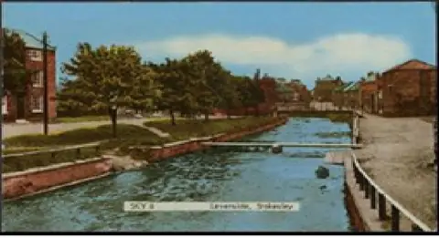 Coloured postcard view of the River Leven with grassy banks, trees and a low footbridge.